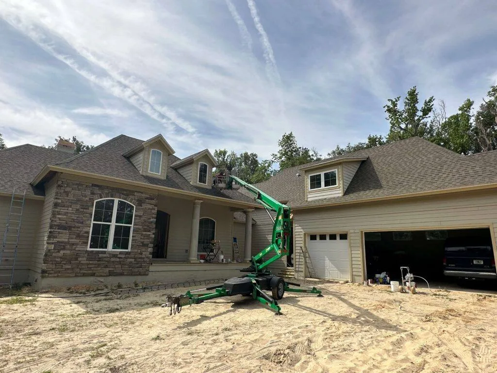 HVR Painting crew painting the exterior of a stone-front house in Gainesville, FL